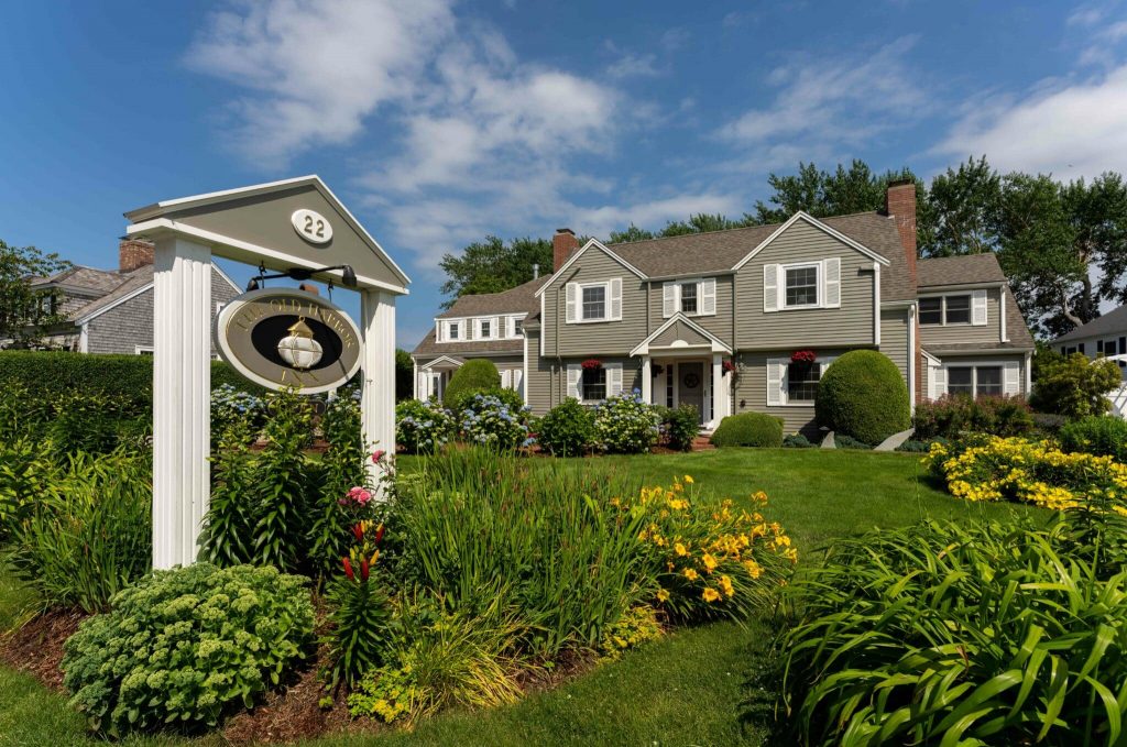 A charming two-story house with a well-kept garden and a signpost featuring number 22.